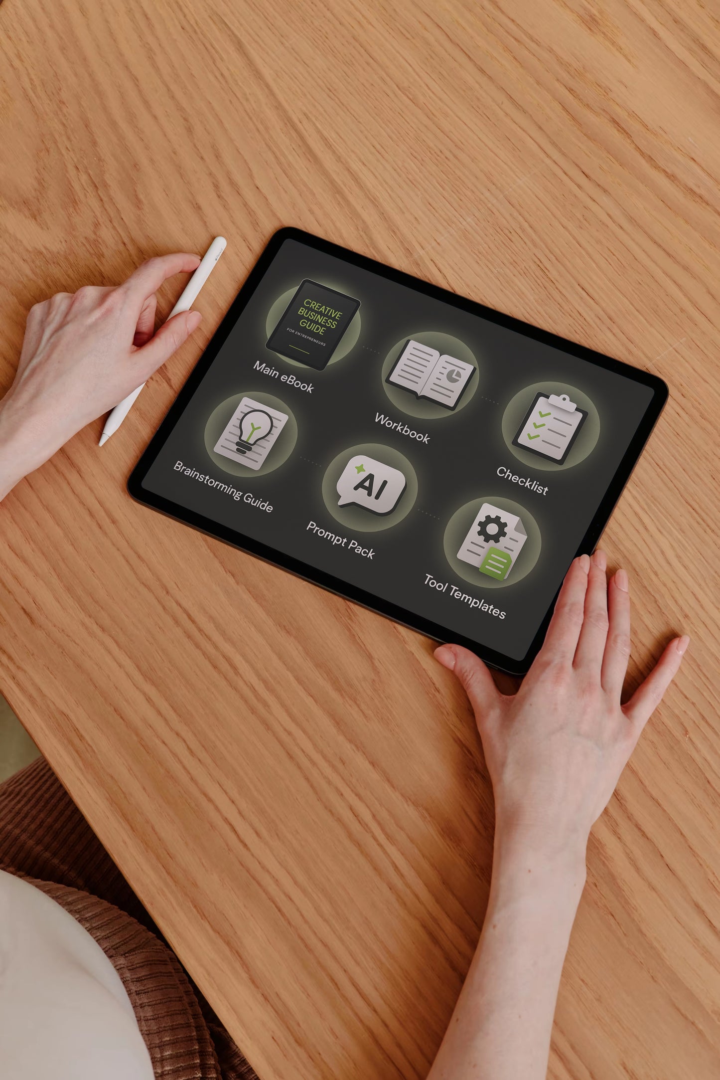 Person using a tablet with app icons on a wooden table